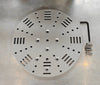 A round silver aluminium mounting plate, with milled slots for straps and mounting holes. With fixing screws and hex key.